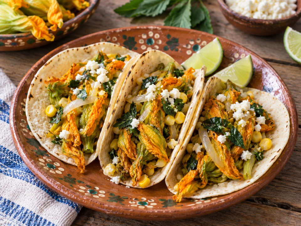 Wilted golden squash blossoms in soft corn tortillas.